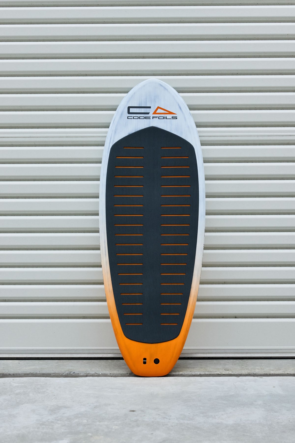 Full deck view of the Code Foils Prone board and black traction pad