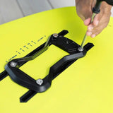 Person using a screwdriver to adjust a duotone quick mount bracket on a wingfoil board