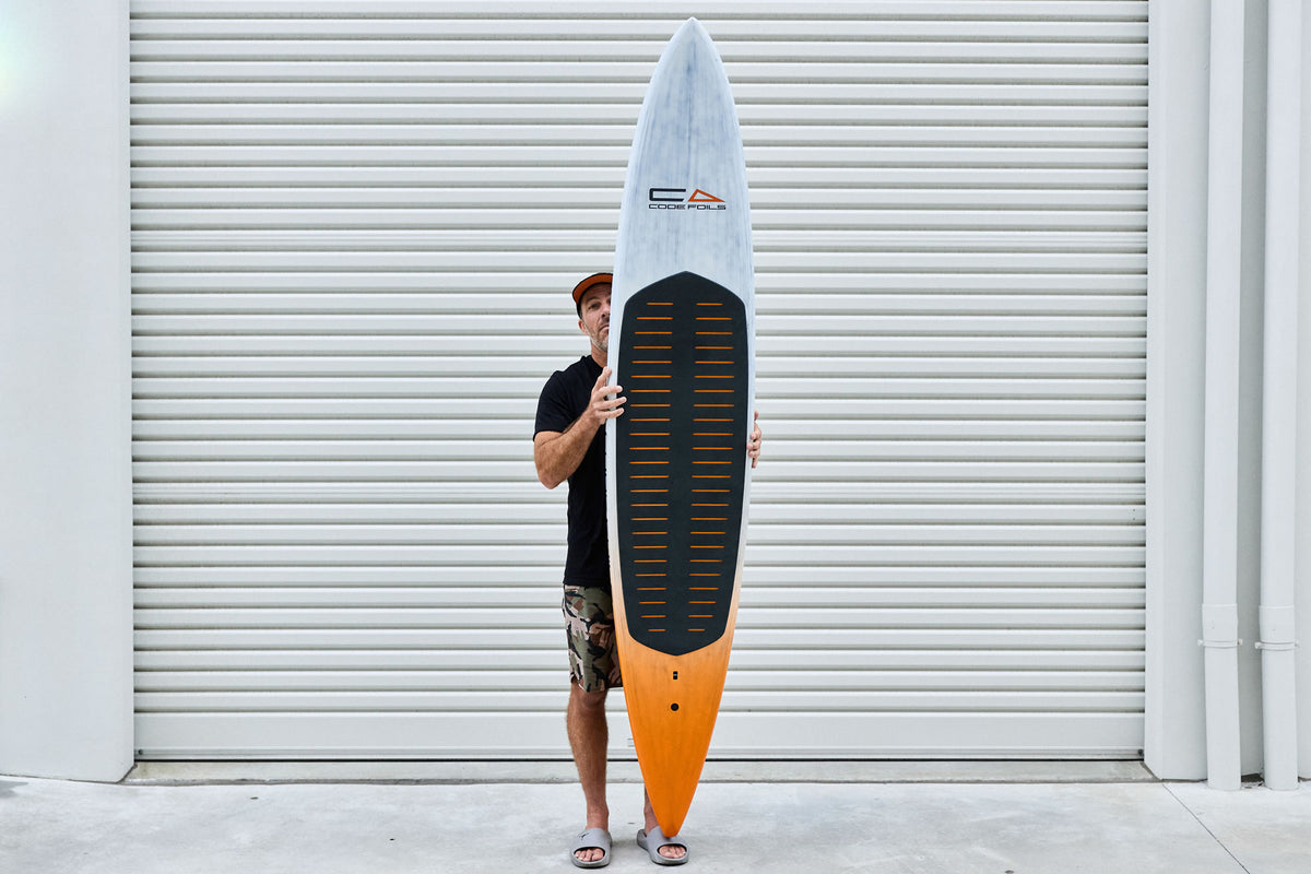 Code Foils Downwind SUP board held vertically with the deck facing forward