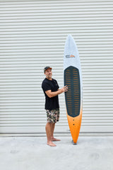 Code Foils Downwind SUP board held upright beside a rider for scale