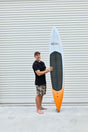 Code Foils Downwind SUP board held upright beside a rider for scale