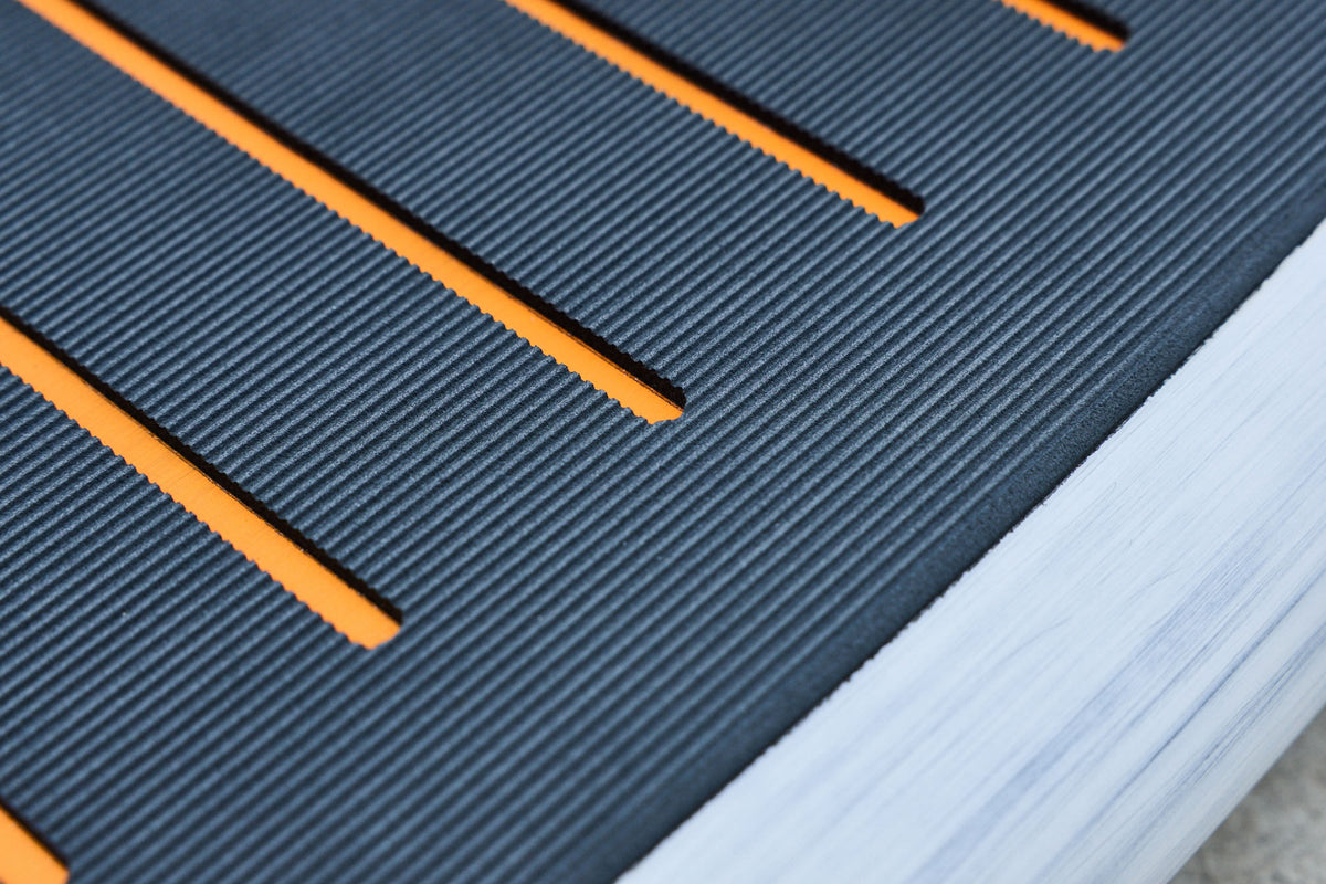 Close view of the Prone board textured deck pad and orange grooves